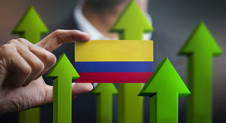 Nation Growth Concept, Green Up Arrows - Businessman Holding Card of Colombia Flag