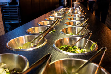 Bowls full of fresh vegetable ingredients for preparing salads in a restaurant.