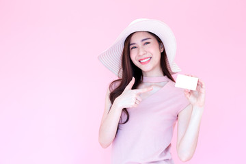 Beautiful young Asian woman smiling and presenting credit card isolated over pink background, Making payment for shopping online or flight ticket, Ecommerce concept