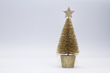 Christmas toy, tree of gold color. New Year. On a gray background, side view.