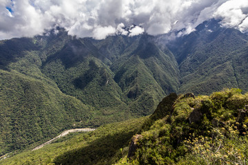 Fototapeta premium Views over the mountains and rainforest around Machu Picchu Citadel an amazing an idyllic scenery to view during a foggy morning. An amazing green landscape to enjoy with our eyes. Inca Trail, Peru