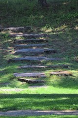 Natural stone staircase outside surrounded by grass