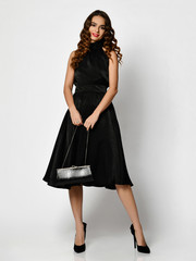 Fototapeta premium Young beautiful woman posing in new black fashion winter dress full body on a white 