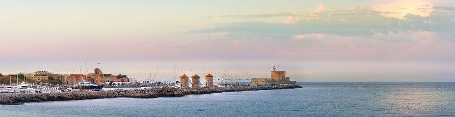 Fototapeta na wymiar Panoramic view of the Windmills and the lighthouse at Mandraki Harbour, Rhodes, Greece.