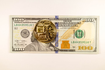 Bitcoin coin lies on 100 dollars bankton on a white background