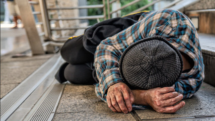 poor homeless beggar sleeping on pathway floor in suffering of unemployment asking for help - obrazy, fototapety, plakaty