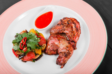 Grilled chicken and salad with grilled vegetables in plate on dark wooden background. Hot Meat Dishes. Top view, flat lay