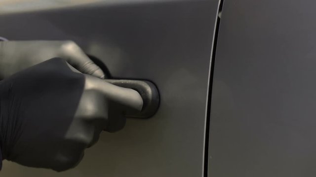 Burglar masterfully working with skeleton key, breaking lock and stealing car