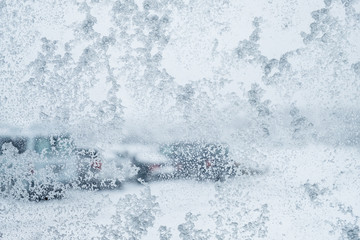 The view though the window during a snowy day. Droplet of the water and snowflakes on the window glass.