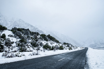 View of a road in Mount Cook Village covered with white fresh snow after a snowy day.