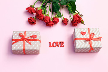 Valentine's Day background. Gift box, red hearts and Valentine day card with copy space on pink background.