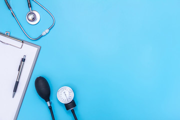 stethoscope and clipboard isolated on blue background