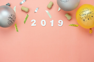 Table top view of Merry Christmas decorations & Happy new year 2019 ornaments concept.Flat lay essential difference objects gift box & balloon with golden confetti on modern pink paper background.