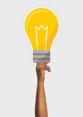 Hand holding a light bulb cardboard prop