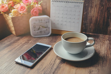 Cup of Coffee with Desktop Calendar 2019,smart phone,clock and pot of flower on blue wooden desk.Calendar for Planner timetable,agenda appointment,organization,management each date,month and year.