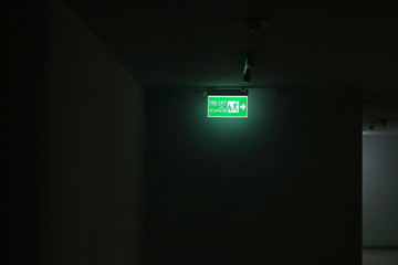 lighting from fire exit sign in the dark corridor of a building