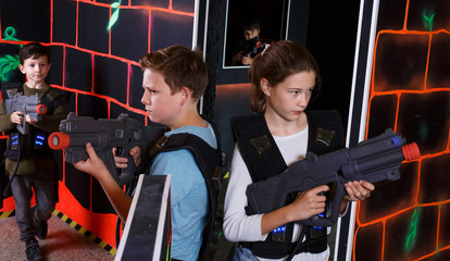 Fototapeta na wymiar Girl and boy playing laser tag