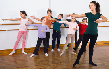 Fototapeta na wymiar Young ballet dancers exercising in ballroom
