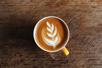 a cup of latte art coffee on wooden background