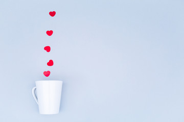White china mug with  glitter heart confetti. Valentine day concept. Trendy minimalistic flat lay design background