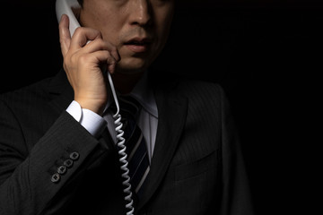 電話で話をするスーツの男性