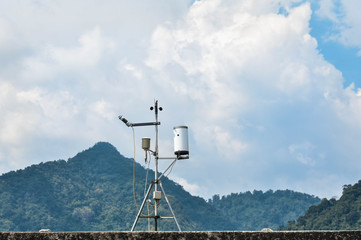 An Anemometers measuring wind speed and weather in mountain view in the background.