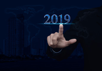 Businessman pressing 2019 text over world map, modern city tower and skyscraper, Happy new year 2019 calendar cover concept, Elements of this image furnished by NASA