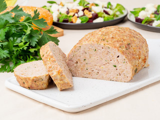 Terrine, meat loaf. Baked Turkey ground meat. Traditional French and American dish. Side view, white marble background