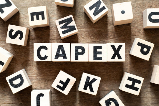 Wood letter block in word CAPEX (Abbreviation of Capital Expenditure) on wood background with another alphabet