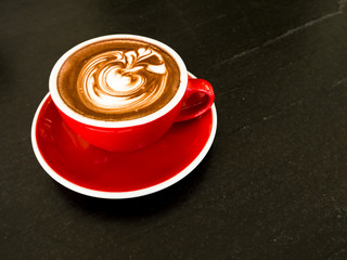 Hot tea and coffee in vintage cup with late art on wood table.