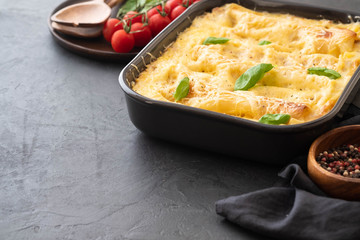 Traditional italian lasagna with vegetables, minced meat and cheese. On a black background. Copy space.