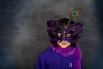 Portrait of a young cute girl with a mask  looking at the camera