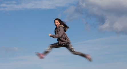 Cute girl running jumping at the on a field in the summer