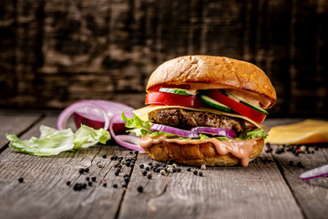 Close-up of home made tasty burger on wooden vintage table. copy space
