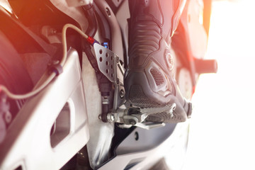 Black leather Moto boots on a red sports bike