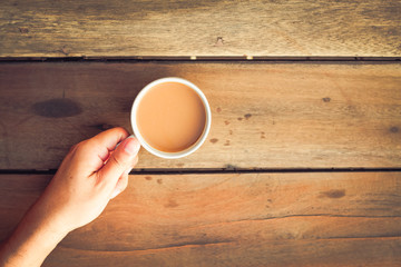 cup of coffee in hand  on the wooden table