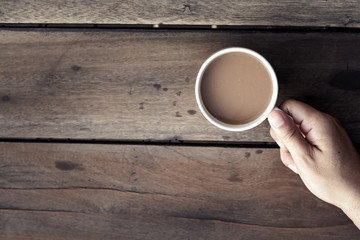cup of coffee in hand  on the wooden table