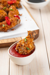 Chicken nuggets with sauce and pepper on a white board. Copy space.