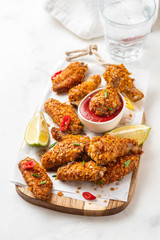 Chicken nuggets with sauce and pepper on a white board. Copy space.