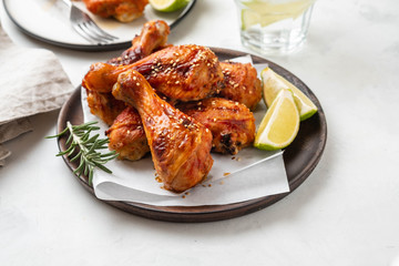 Chicken legs with sauce, rosemary and lime on a white background. Copy space.