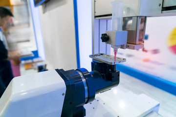 Robot holding glue syringe Injection in mobile phone factory