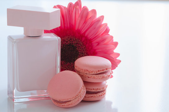 Beautiful pink perfume bottles with flower and macaroons.  Luxury perfumery background