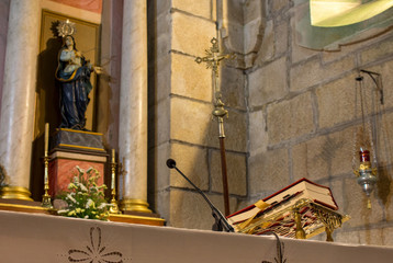Red Bible on altar table with microphone and saint sculpture. Faith and religion concept. Church...