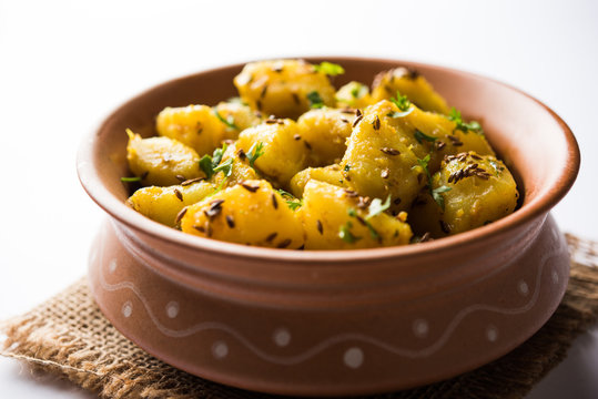 Jeera Aloo is a Indian main course dish which goes well with hot puris, chapatti, roti or dal. served in a bowl over moody background. selective focus
