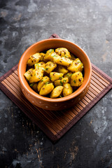 Jeera Aloo is a Indian main course dish which goes well with hot puris, chapatti, roti or dal. served in a bowl over moody background. selective focus