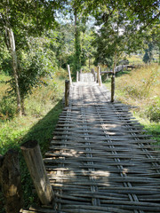 Romantic bamboo bridge crossing fields and nature, Northern Thailand landscape