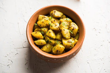 Jeera Aloo is a Indian main course dish which goes well with hot puris, chapatti, roti or dal. served in a bowl over moody background. selective focus