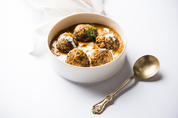 Malai Kofta is a Mughlai Speciality dish served in a bowl or pan over moody background. selective focus