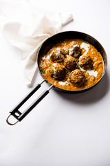 Malai Kofta is a Mughlai Speciality dish served in a bowl or pan over moody background. selective focus
