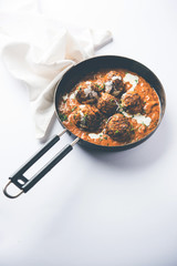 Malai Kofta is a Mughlai Speciality dish served in a bowl or pan over moody background. selective focus